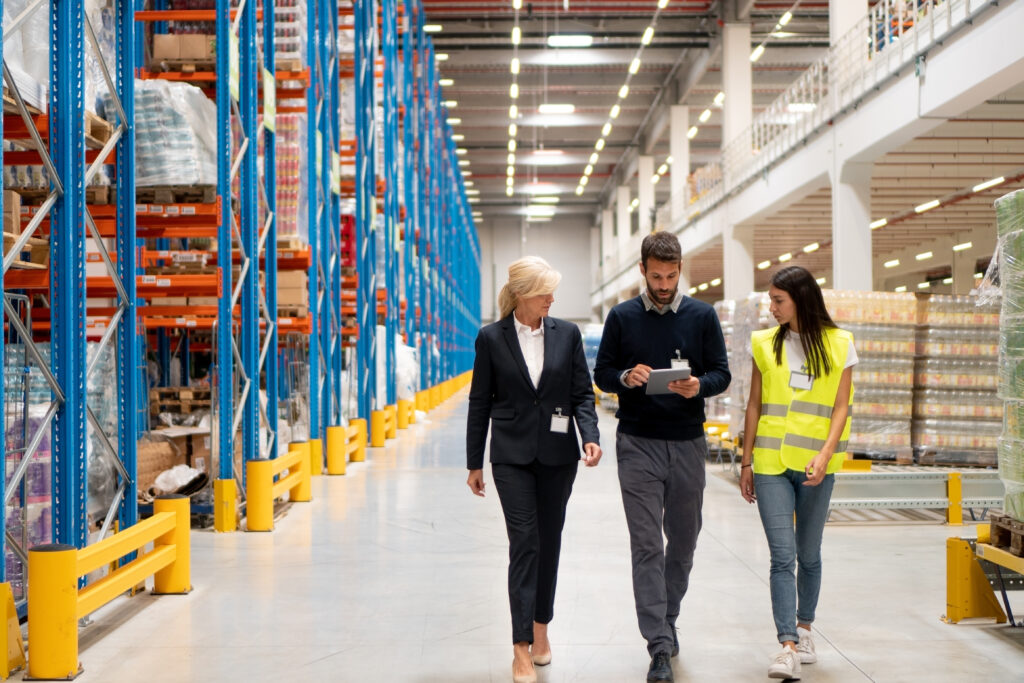 People walking through a warehouse and assessing the workflow